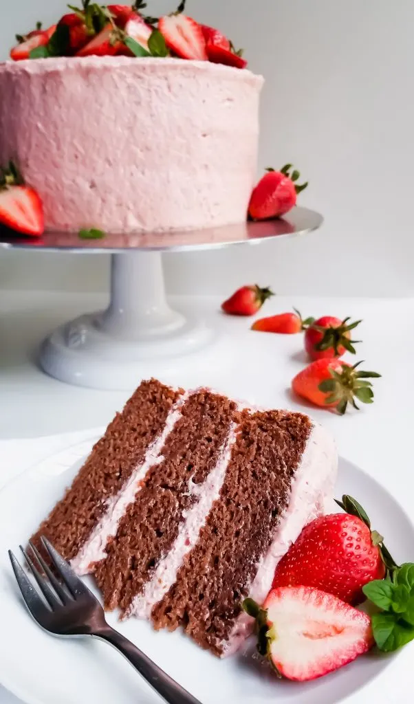 Vegan Strawberry Layer Cake with Strawberry Cream Cheese Frosting sliced and served with fresh strawberries