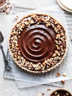 Flatlay of chocolate hazelnut tart on a cooling rack