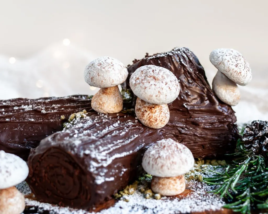 Vegan Chocolate Yule Log with Meringue Mushrooms served with candy snow and rosemary branches