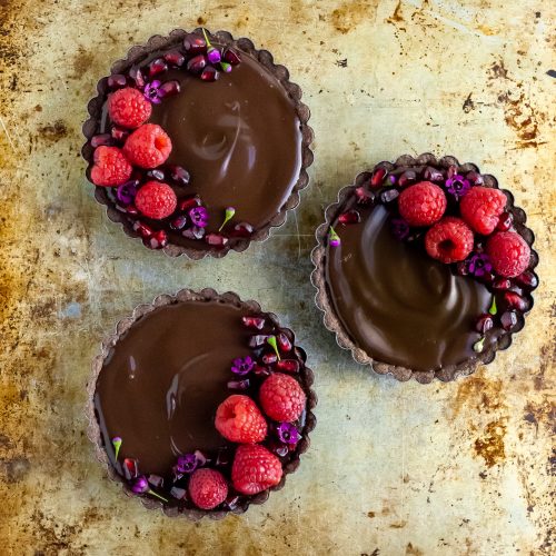 3 Chocolate Raspberry Dream Tartlets garnished with raspberries and pomengranate arils
