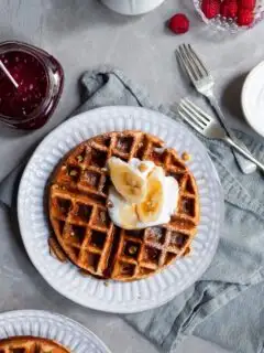Vegan Banana Waffle on breakfast table served with fresh bananas and maple syrup