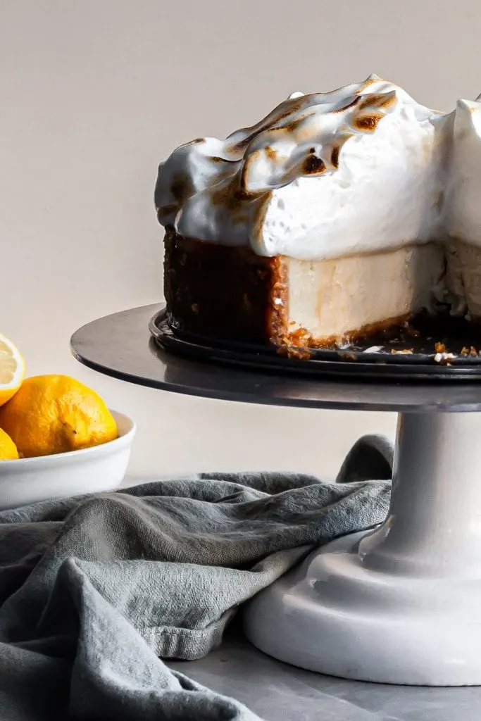 Crosseection of Vegan Lemon Meringue Baked Cheesecake closeup of creamy interior and tall pillowy meringue