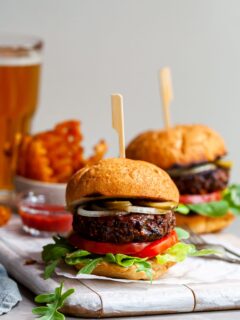 Vegan burger served in a toasted bun with pickles, sliced onions, lettuce and tomatoes.