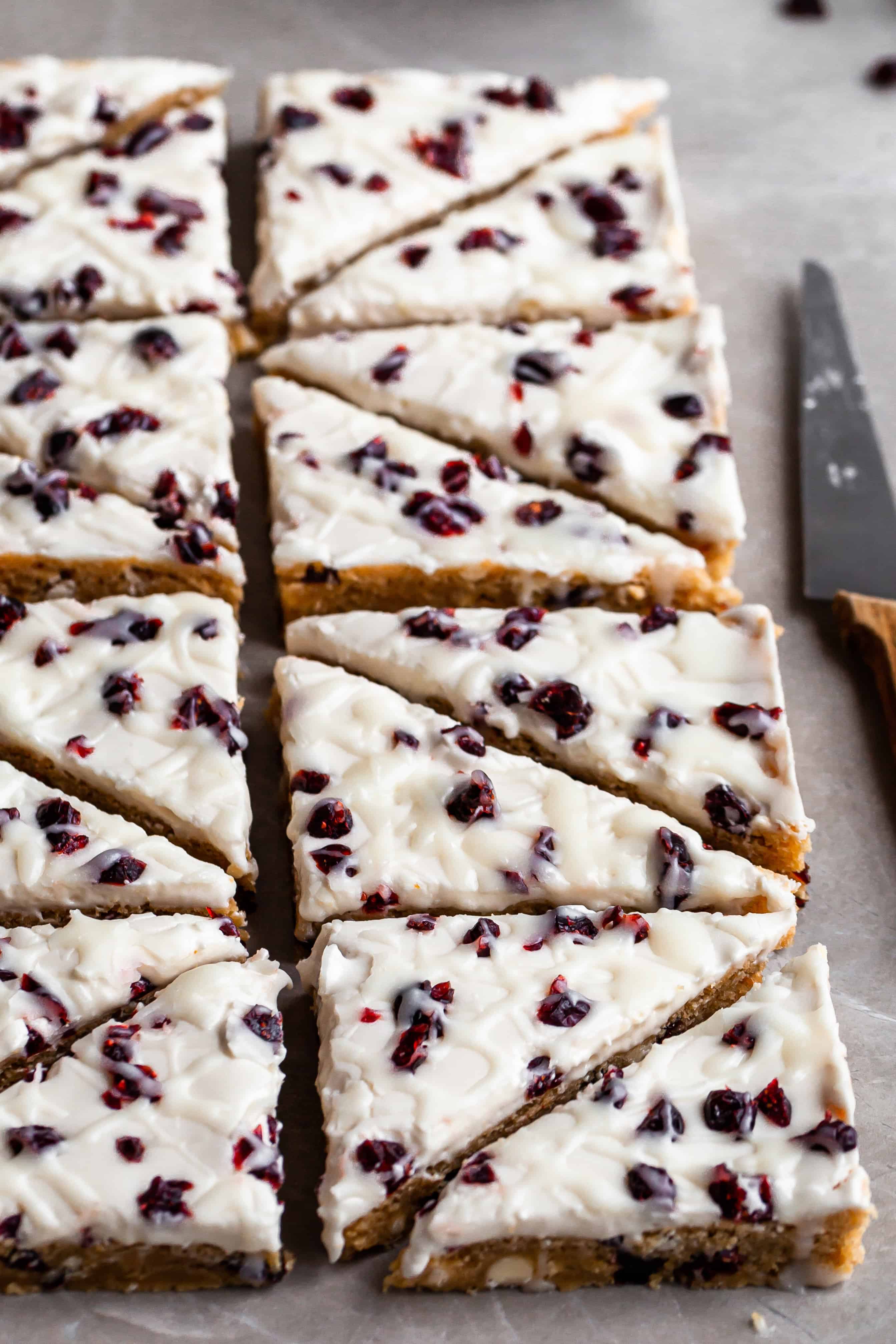 Vegan Cranberry Bliss Bars, sliced into triangles, angled side view