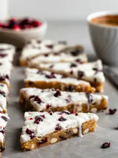 Vegan Cranberry Bliss Bars, cut into triangles and a cup of espresso in background