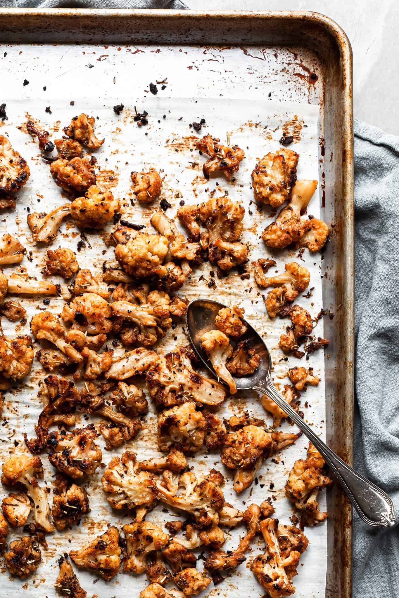 roasted cauliflower on a baking sheet - well caramelized and seasoned with Greek spices