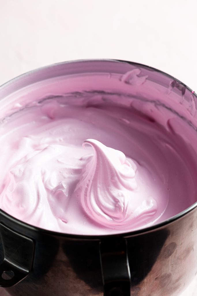 Close up into a bowl of pink meringue