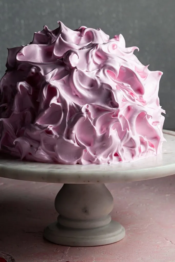 A pink baked Alaska before the meringue has been toasted, appearing glossy