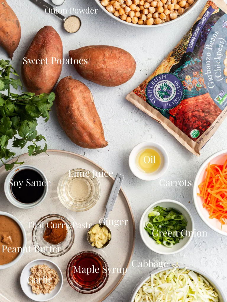 View looking down on a white counter filled with the ingredients labelled for this Thai peanut stuffed sweet potato recipe. 