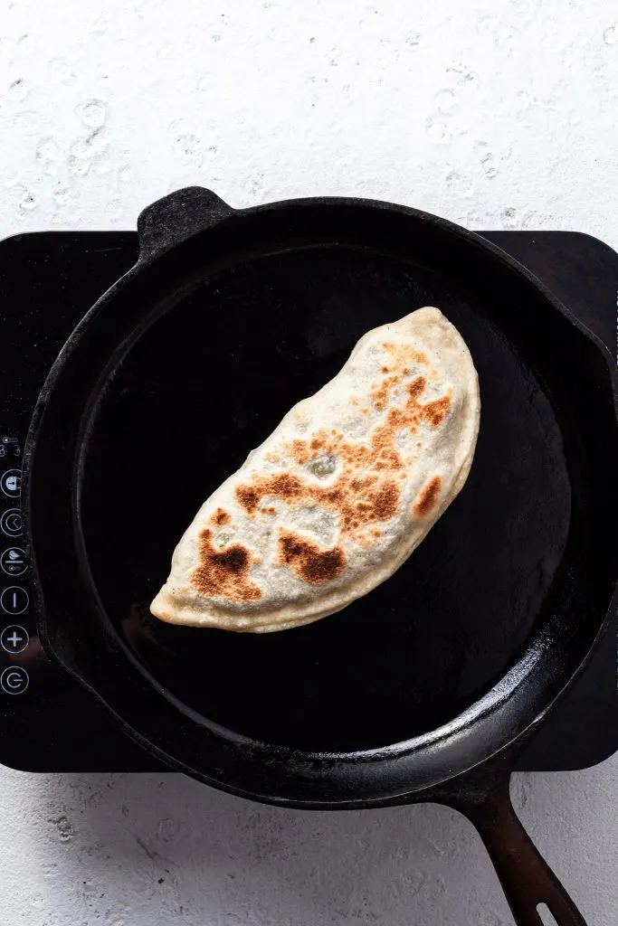 Bolani or stuffed flatbread cooked in a cast iron skillet. 