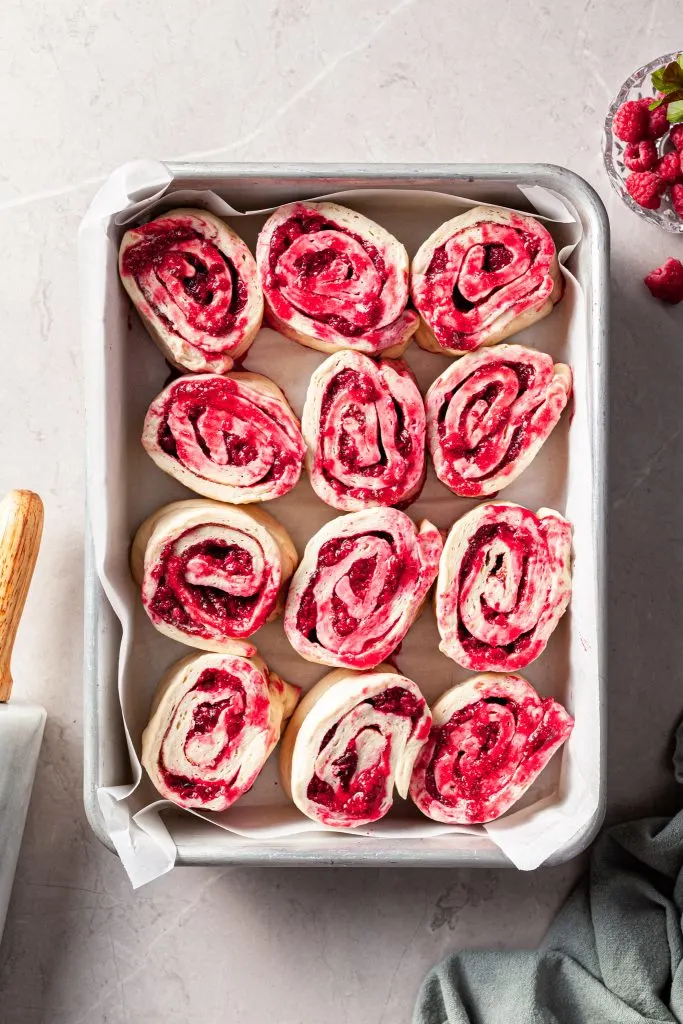 Raspberry sweet rolls in a baking pan ready to be baked.