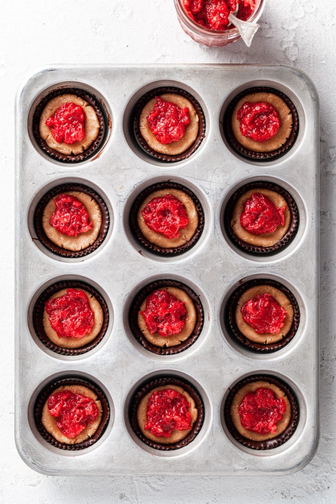 Peanut butter and jam cups in a muffin tin before the final coating of chocolate