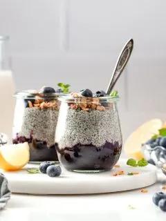 Breakfast parfaits made of chia pudding layer over blueberry compote served in small jars