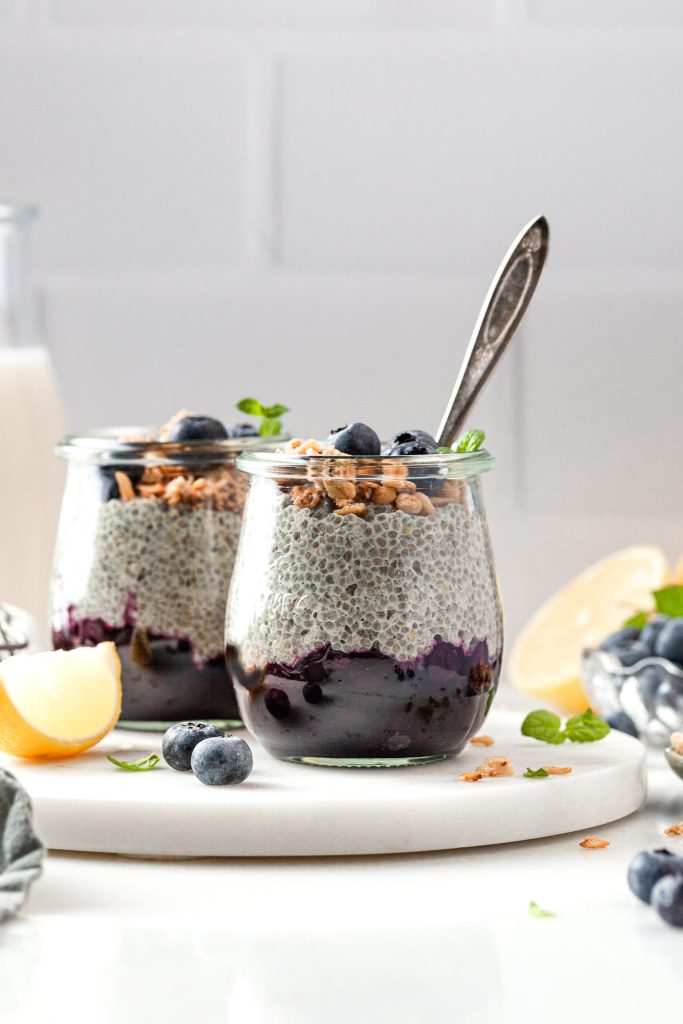 Breakfast parfaits made of chia pudding layer over blueberry compote served in small jars