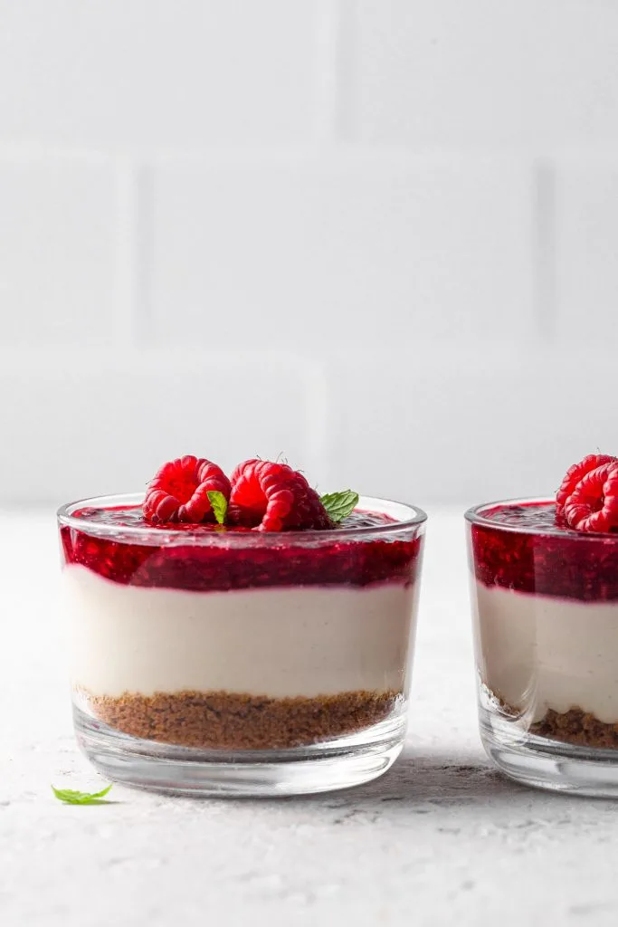 Two jars of vegan cheesecakes side by side on a white counter