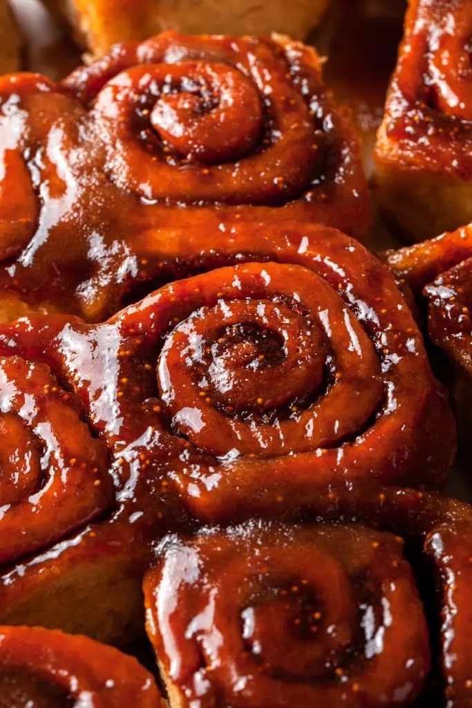 A close up of the glazed tops of a few sticky fig buns. 