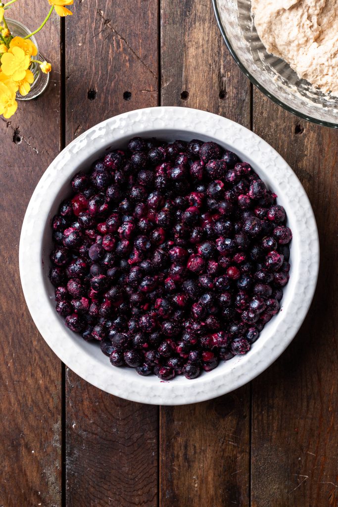 A white round baking dish filled with frozen blueberries. 